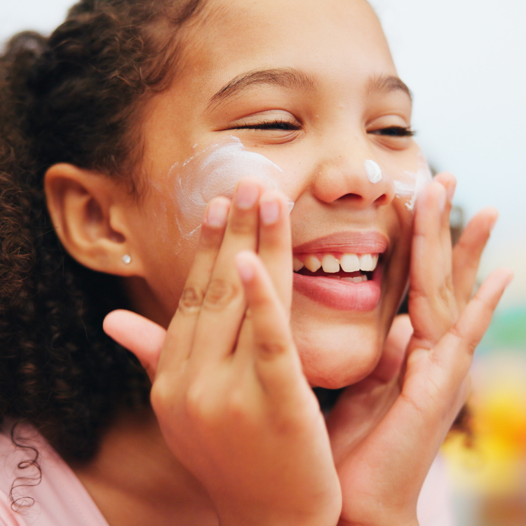 June-blog-2 young girl puts sunscreen on her face