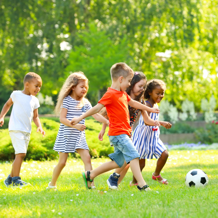 T&C blog – july 2026 A group of diverse children running around on a sunny day, having fun while kicking a soccer ball.
