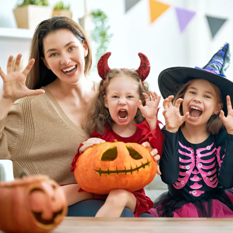 October-blog-2 Two young girls and their mother making play faces at the camera, pretending to be scary. The young girls are dressed in halloween costumes.